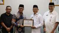IMG-20250409-WA0009 Ket foto: Syamsul Masjan saat menyerahkan dana hibah sisa pelaksanaan Pilkada kepada Bupati Inhil Haji Herman, Rabu (9/4/2025).