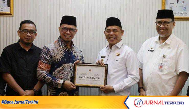 Ket foto: Syamsul Masjan saat menyerahkan dana hibah sisa pelaksanaan Pilkada kepada Bupati Inhil Haji Herman, Rabu (9/4/2025).