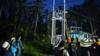 Ket Foto:Petugas PLN sedang menghidupkan aliran listrik 24 jam di Pelangiran kecil dan Desa Teluk Bunian