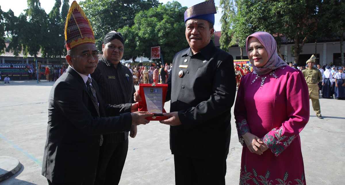 upacara hardiknas di asahan Bupati Asahan menyerahkan penghargaan di sela upacara Hardiknas di SMPN 2 Kisaran, Jumat (2/5/2025). (diskominfo asahan)