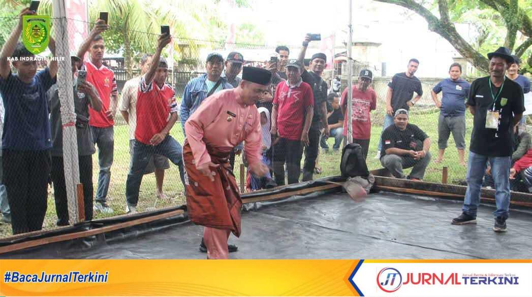Ket Foto: H Herman Bupati Inhil saat memainkan Gasing tradisional dalam rangka memeriahkan milad Inhil ke- 60