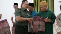 Kasdim 0317/TBK Mayor Inf Istain Tamimi menyerahkan bingkisan kepada peserta yang hadir dalam acara komunikasi sosial di Makodim 0317/TBK, Selasa (24/6/2026). (JurnalTerkini.id/edy kencana)