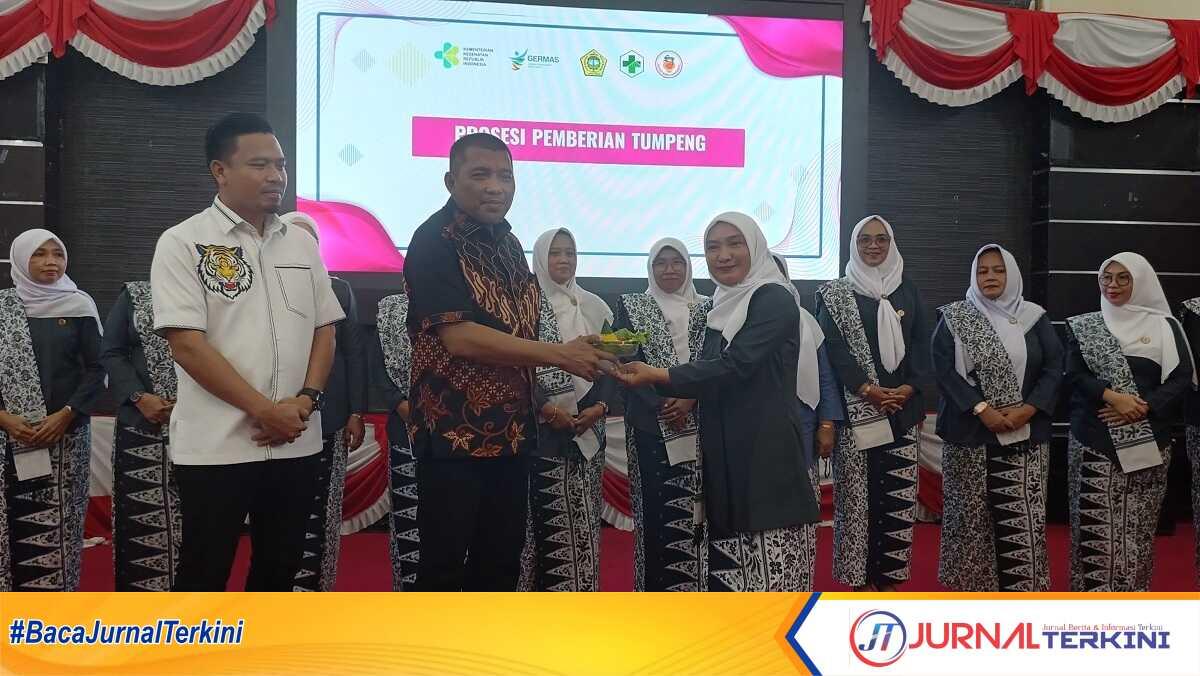 Wakil Bupati Karimun, Rocky Marciano Bawole menyerahkan tumpeng kepada ketua IBI cabang Karimun, Nilma dalam acara HUT Ikatan Bidan Indonesia (IBI) ke-74 disejalankan dengan hari bidan sedunia di Gedung Nasional, Tanjung Balai Karimun, Selasa (24/06/2025). (JurnalTerkini.id/edy kencana)