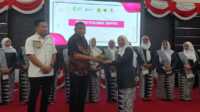 Wakil Bupati Karimun, Rocky Marciano Bawole menyerahkan tumpeng kepada ketua IBI cabang Karimun, Nilma dalam acara HUT Ikatan Bidan Indonesia (IBI) ke-74 disejalankan dengan hari bidan sedunia di Gedung Nasional, Tanjung Balai Karimun, Selasa (24/06/2025). (JurnalTerkini.id/edy kencana)