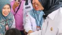 starlink di Dharmasraya Bupati Annisa Suci Ramadhani menyalami seorang siswa saat mengunjungi sebuah sekolah di Pulau Punjung, Kamis (15/5/2025). (Humas Pemkab Dharmasraya)