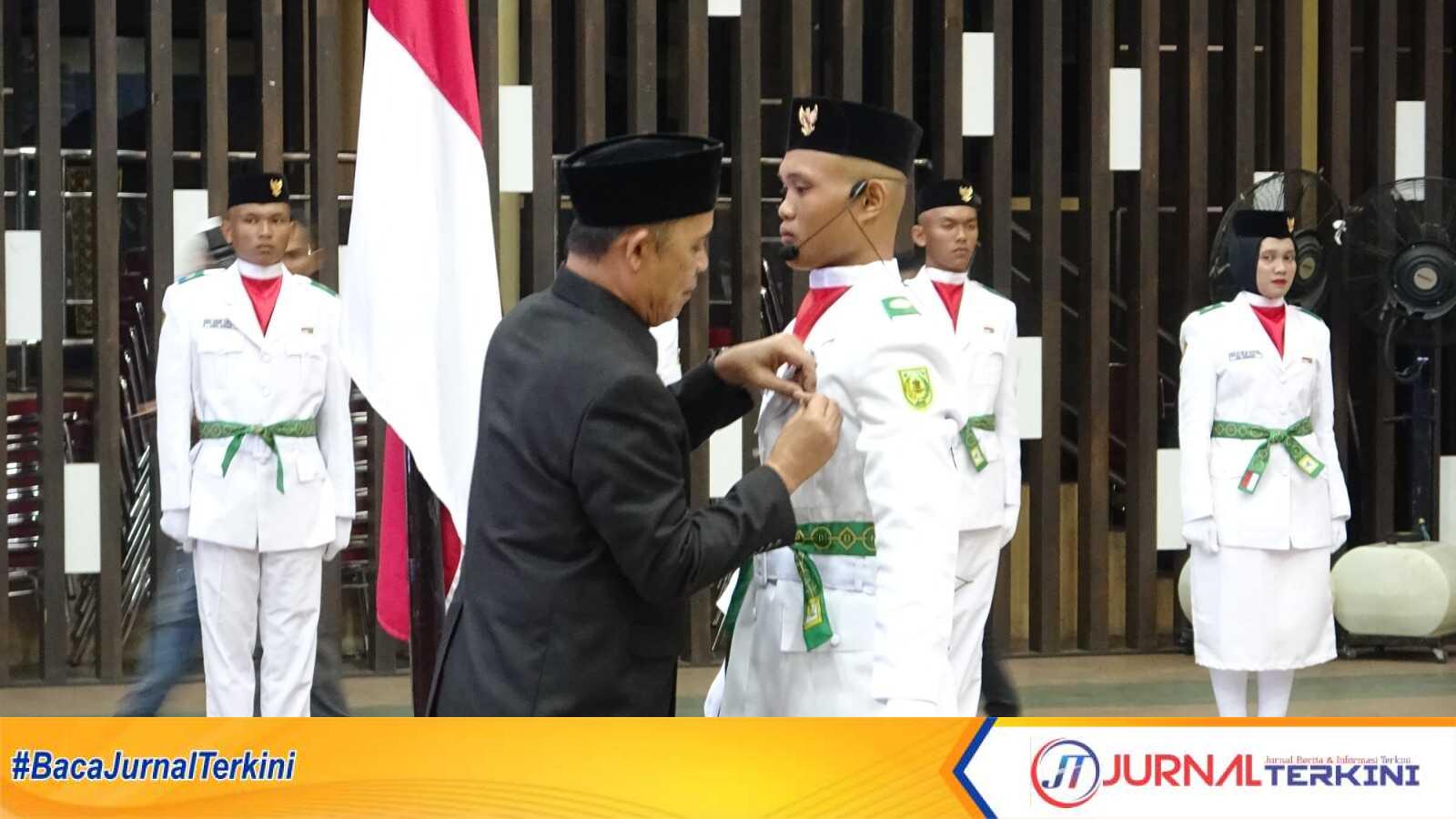 Ket Foto: Bupati Indragiri Hilir, Haji Herman saat pemasangan kendit dan penyematan tanda penghargaan kepada perwakilan anggota Paskibraka yang digelar di Gedung Engku Kelana, Tembilahan, Jumat (15/8/2025).