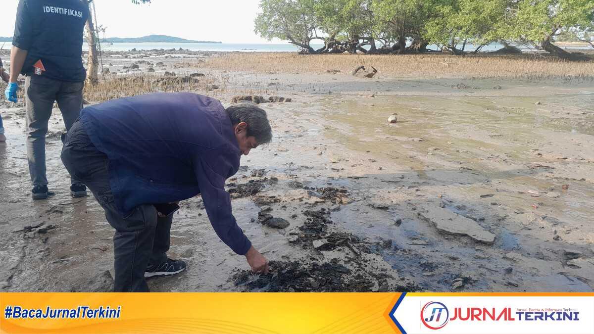 Seorang warga mengamati lapisan berwarna hitam diduga limbah B3 disamping area PT KSS, Kamis (9/10/2025). (JurnalTerkini.id/rusdi)