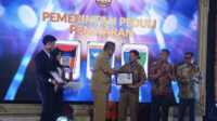 Asisten II Bidang Perekonomian dan Pembangunan Setda Kota Padang, Didi Aryadi saat menerima penghargaan. (Foto Kominfo Padang).