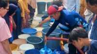 Warga terdampak bencana Banjir dan longsor di Kota Padang saat mengantri untuk mendapatkan air besar. (Foto Kominfo Padang).