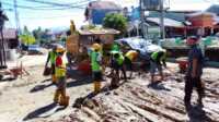 Petugas terkait sedang membersihkan sedimen dan sampah banjir di Kota Padang. (Foto Kominfo Padang).