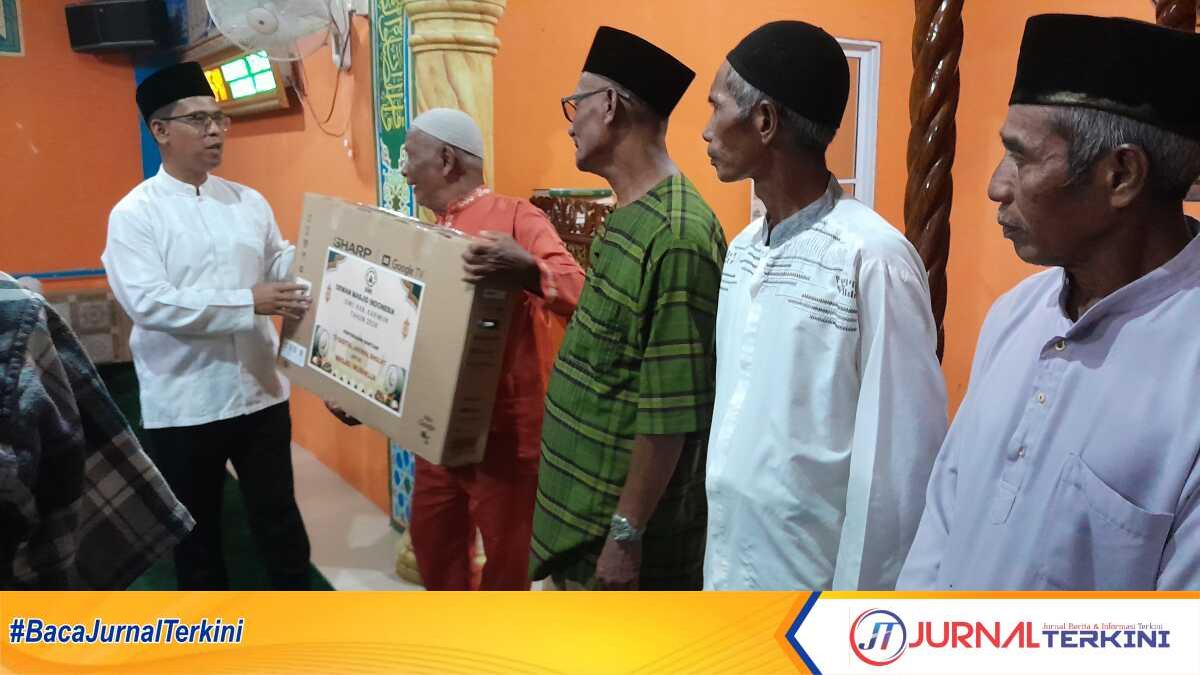 Bupati Karimun Iskandarsyah menyerahkan bantuan layar digital atau LED dan santunan kepada pengurus Masjid Baitul Hikmah, Teluk Paku, Kelurahan Pasir Panjang, Kecamatan Meral Barat, Senin (23/2/2026). (JurnalTerkini.id/rusdi)