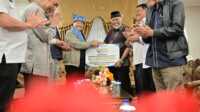 Ketua Umum PERADI, Otto Hasibuan, saat menyerahkan bantuan kepada Gubernur Sumbar. (Foto Adpim Sumbar).