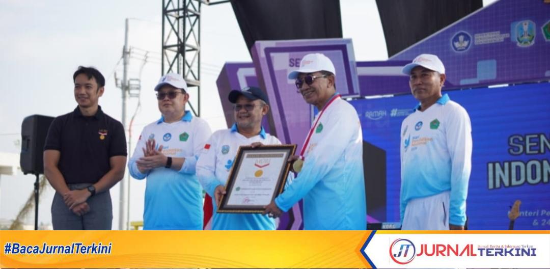 Menteri Pendidikan Dasar dan Menengah RI, Abdul Mu'ti menyerahkan penghargaan MURI kepada Bupati Pamekasan, Kholilurrahman pada puncak Hardiknas 2026 di Pamekasan.