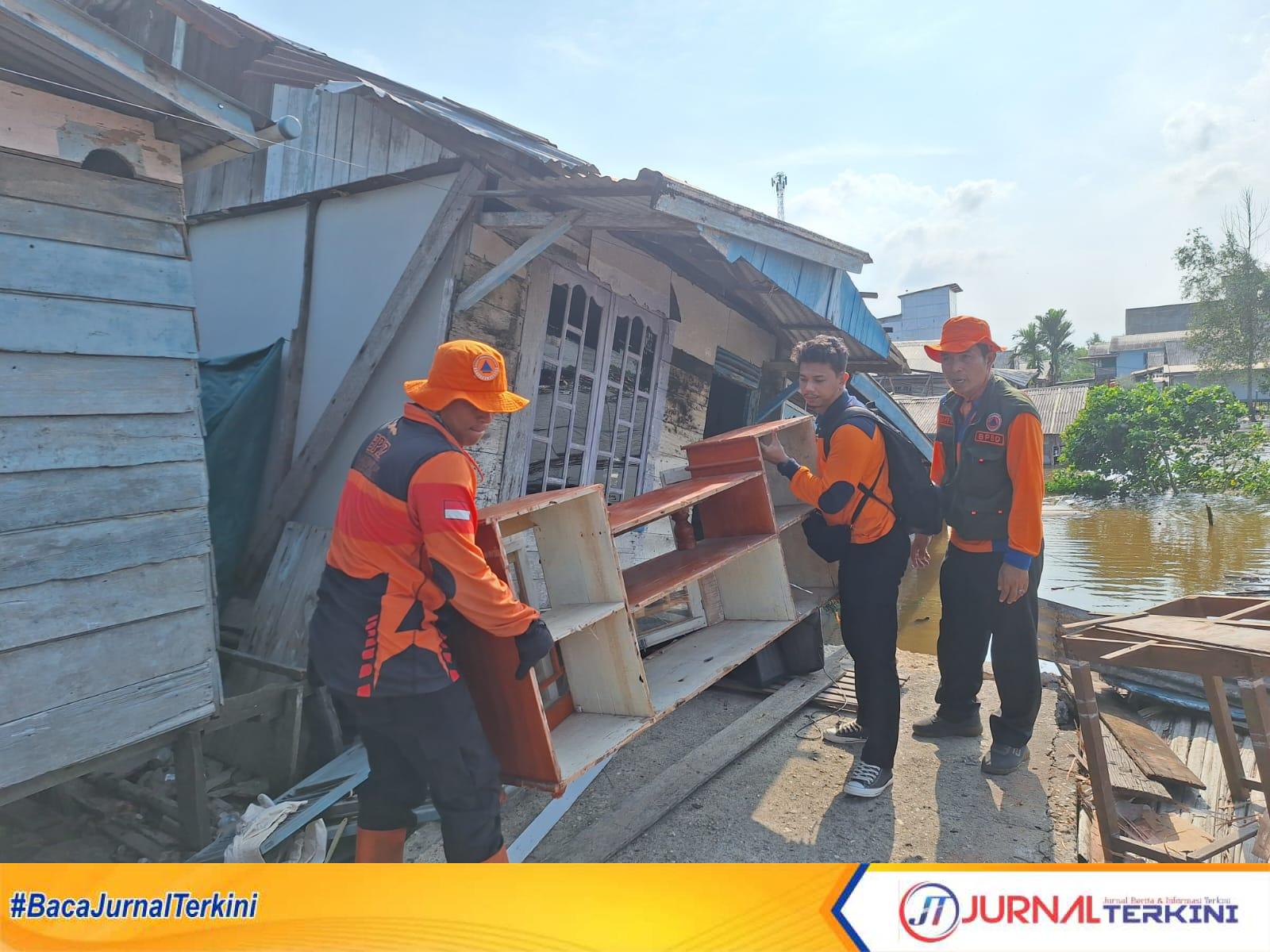 Ket Foto: Tim BPBD Inhil melakukan evakuasi harta benda korban abrasi (longsor) di Sungai Udang Desa Sungai Nyiur