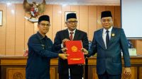 Ketua DPRD Karimun Raja Rafiza (tengah) bersama Bupati Iskandarsyah (kiri) dan Wakil Ketua DPRD Ady Hermawan menunjukkan naskah Ranperda dalam rapat paripurna di DPRD Karimun, Kamis (17/9/2026).