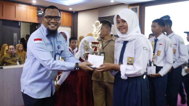 Ketua Forum Tanggung Jawab Sosial Perusahaan (TJSP) Kabupaten Karimun Ferry Kurniawan menyerahkan hadiah kepada salah satu peserta lomba gerak jalan di Kantor Bupati Karimun beberapa hari lalu. (Dokumentasi pribadi)