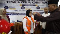 Wakil Bupati Karimun Rocky Marciano Bawole mengalungkan tanda peserta kepada salah satu peserta pembekalan, pelatihan, dan sertifikasi bagi 75 tenaga kerja konstruksi di Tanjung Balai Karimun, Rabu (23/9/2026). (Foto: Diskominfostaper Karimun)