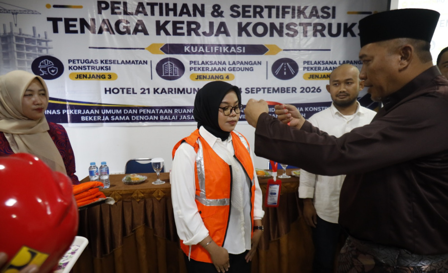 Wakil Bupati Karimun Rocky Marciano Bawole mengalungkan tanda peserta kepada salah satu peserta pembekalan, pelatihan, dan sertifikasi bagi 75 tenaga kerja konstruksi di Tanjung Balai Karimun, Rabu (23/9/2026). (Foto: Diskominfostaper Karimun)